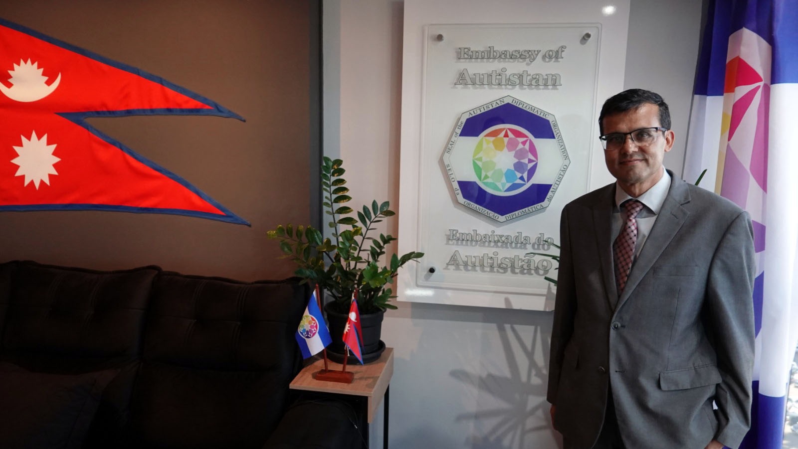 Près de la plaque de l’Ambassade d’Autistan, marquant le caractère symbolique de la visite.
